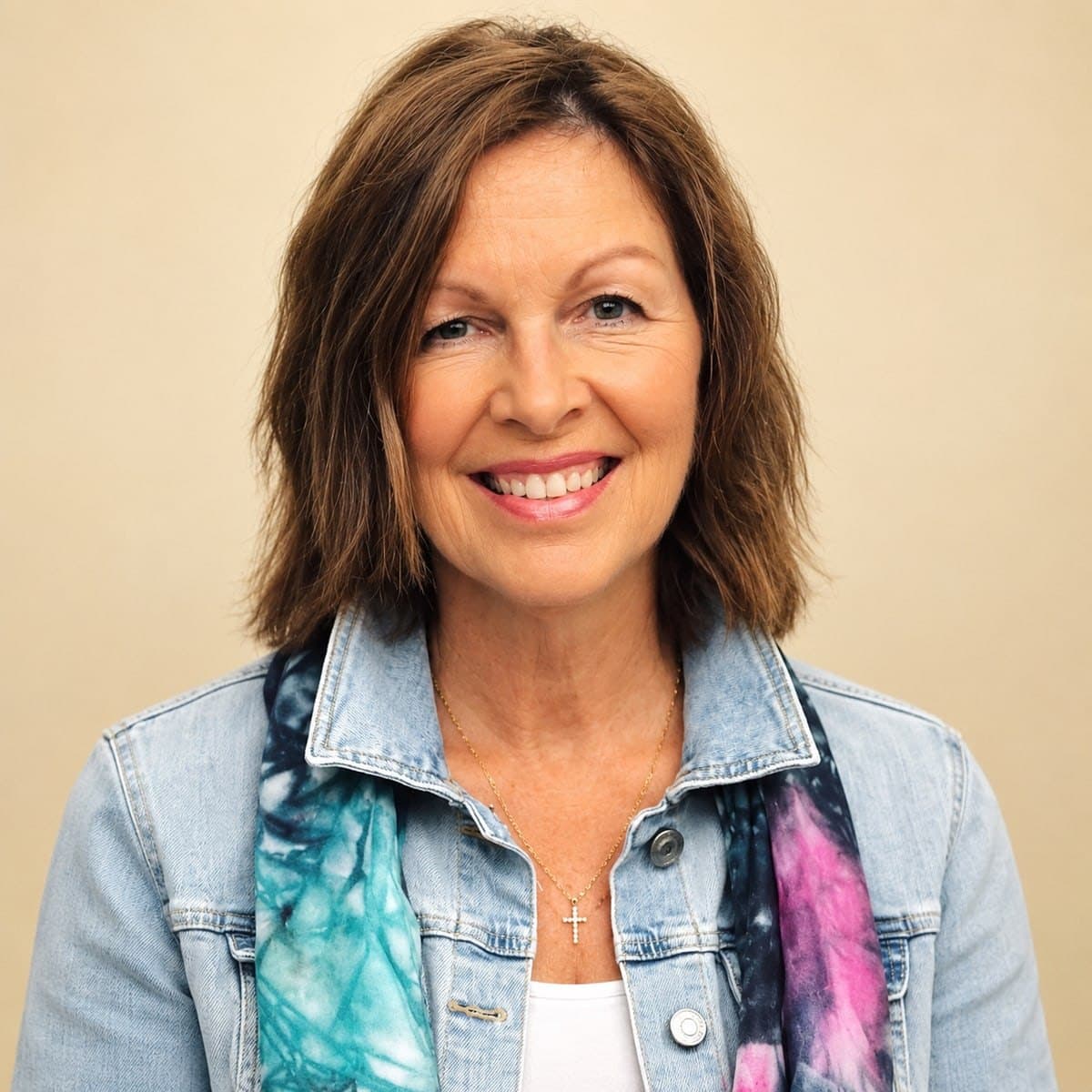 Barbie Hunt, smiling, in a denim jacket with a hand-dyed teal and pink silk scarf